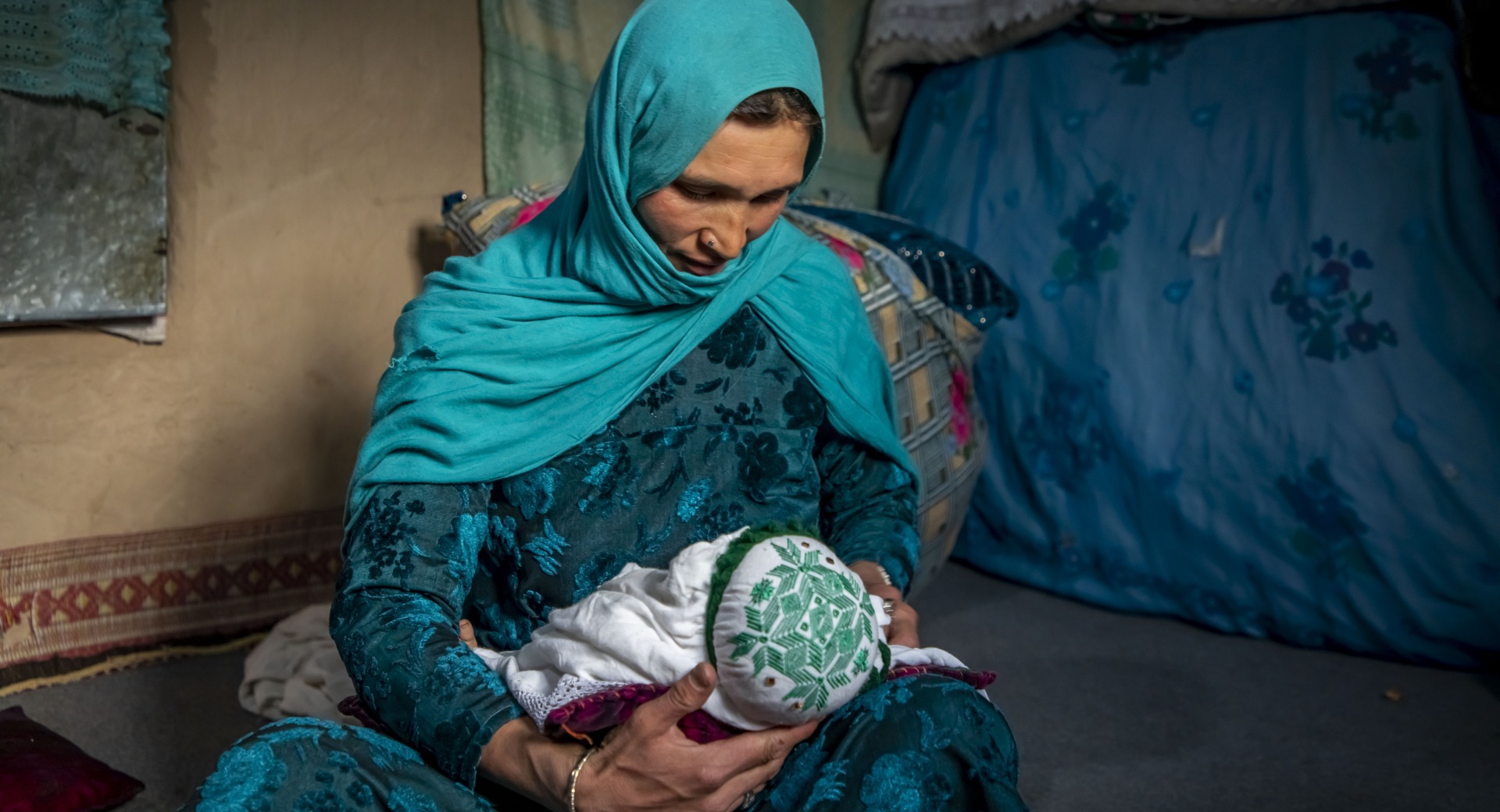 Nadia nurses her youngest child, 2 months old, at home in Duykondi Province, Afghanistan. Action Against Hunger works in this area to manage feeding programs and provide mobile health and nutrition support.